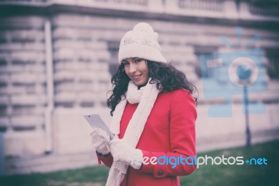 Beautiful Woman In Red Coat And Wool Cap And Gloves With Smartph… Stock Photo