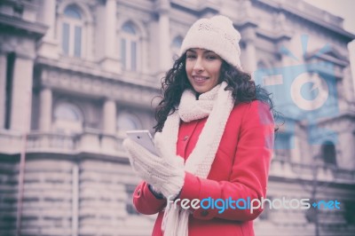 Beautiful Woman In Red Coat And Wool Cap And Gloves With Smartph… Stock Photo