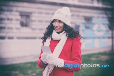 Beautiful Woman In Red Coat And Wool Cap And Gloves With Smartph… Stock Photo