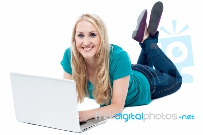 Beautiful Woman Lying On The Floor, Using Laptop Stock Photo