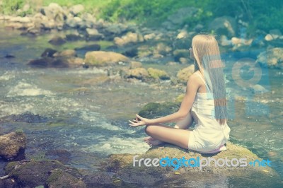 Beautiful Woman Practive Yoga On River In Nature Stock Photo