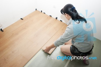 Beautiful Woman Puts Laminate Flooring Stock Photo