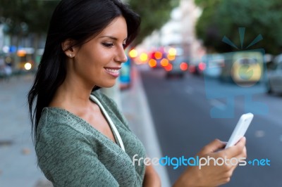 Beautiful Woman Use Her Phone In The City At Night Stock Photo