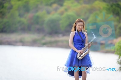 Beautiful Woman Wear Blue Evening Dress Holding Saxophone Stand Stock Photo