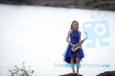 Beautiful Woman Wear Blue Evening Dress Holding Saxophone Stand Stock Photo