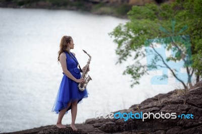 Beautiful Woman Wear Blue Evening Dress Holding Saxophone Stand Stock Photo