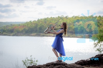 Beautiful Woman Wear Blue Evening Dress Sound Saxophone Stand On… Stock Photo