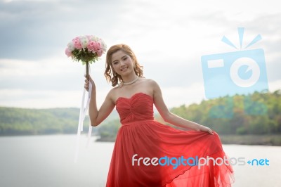 Beautiful Woman Wear Red Evening Dress Hold A Bouquet Of Flowers… Stock Photo