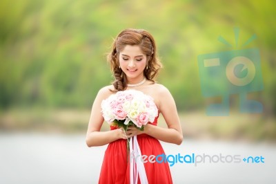 Beautiful Woman Wear Red Evening Dress Hold A Bouquet Of Flowers… Stock Photo