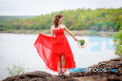 Beautiful Woman Wear Red Evening Dress Hold A Bouquet Of Flowers… Stock Photo