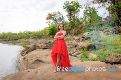 Beautiful Woman Wear Red Evening Dress Over Mountains And Rivers… Stock Photo