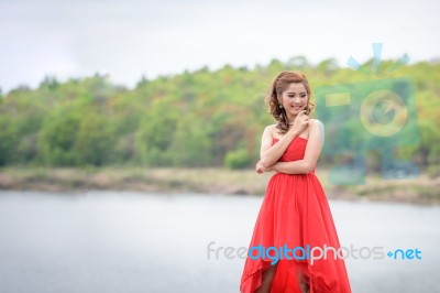 Beautiful Woman Wear Red Evening Dress Over Mountains And Rivers… Stock Photo