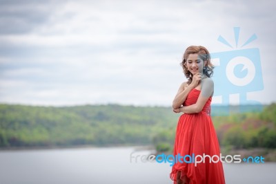 Beautiful Woman Wear Red Evening Dress Over Mountains And Rivers… Stock Photo