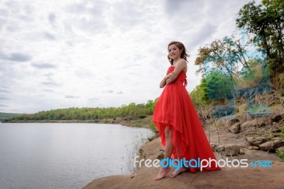 Beautiful Woman Wear Red Evening Dress Over Mountains And Rivers… Stock Photo