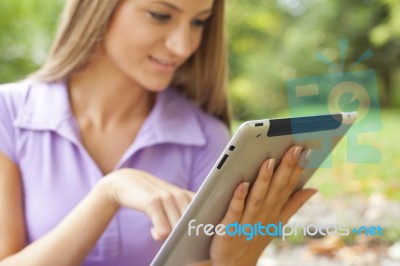 Beautiful Woman With Tablet Computer In Park Stock Photo