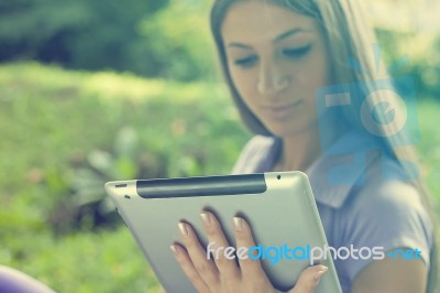 Beautiful Woman With Tablet Computer In Park Stock Photo