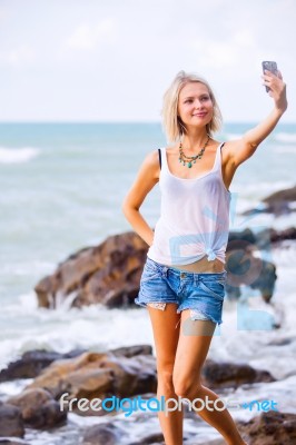 Beautiful Young Blonde Woman Posing Outdoor At The Rocky Sea Sho… Stock Photo