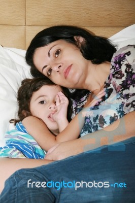 Beautiful Young Mother And Her Daughter On The Bed Stock Photo