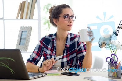 Beautiful Young Woman Drinking Coffee In Her Office Stock Photo