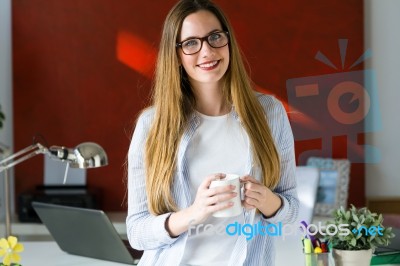 Beautiful Young Woman Drinking Coffee In The Office Stock Photo