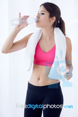 Beautiful Young Woman Drinking Water After A Workout At Home Stock Photo