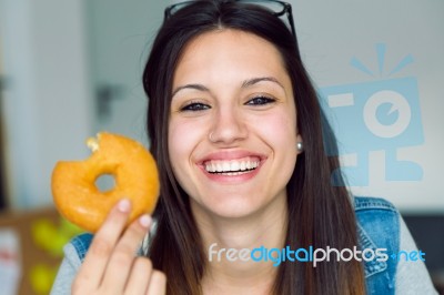 Beautiful Young Woman Eating Donuts At Home Stock Photo