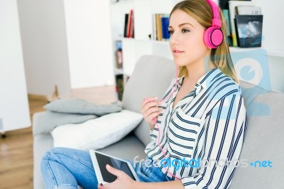 Beautiful Young Woman Listening To Music With Digital Tablet Stock Photo