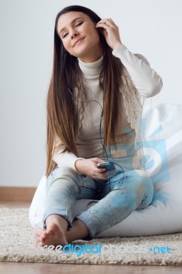 Beautiful Young Woman Listening To Music With Mobile Phone At Ho… Stock Photo