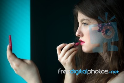 Beautiful Young Woman Putting On Lipstick Stock Photo