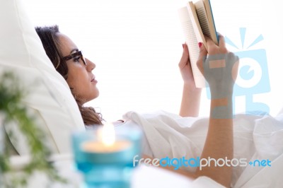 Beautiful Young Woman Reading A Book In The Bed Stock Photo