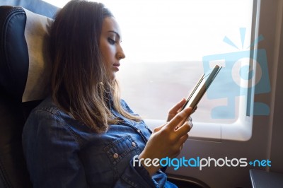 Beautiful Young Woman Reading A Book In The Train Stock Photo