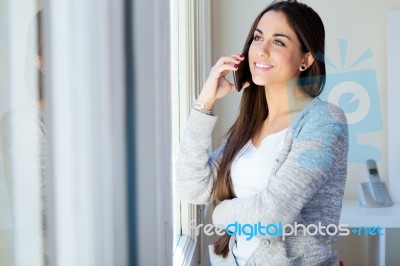 Beautiful Young Woman Talking On The Phone At Home Stock Photo