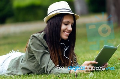 Beautiful Young Woman Using Digital Tablet In The Park Stock Photo