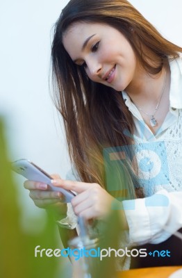 Beautiful Young Woman Using Her Mobile Phone At Cafe Shop Stock Photo