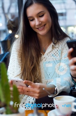 Beautiful Young Woman Using Her Mobile Phone At Cafe Shop Stock Photo