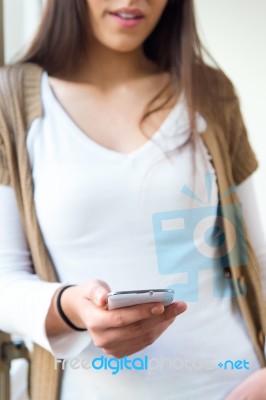 Beautiful Young Woman Using Her Mobile Phone At Home Stock Photo