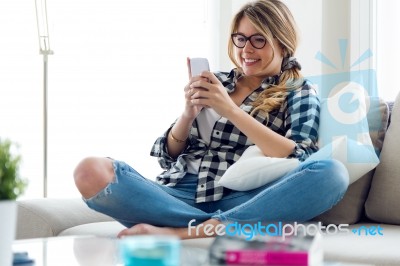 Beautiful Young Woman Using Her Mobile Phone At Home Stock Photo