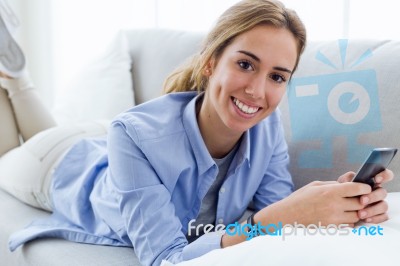 Beautiful Young Woman Using Her Mobile Phone At Home Stock Photo