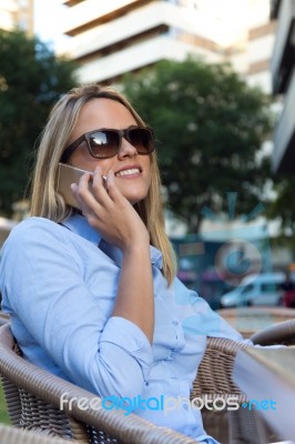 Beautiful Young Woman Using Her Mobile Phone In A Restaurant Ter… Stock Photo