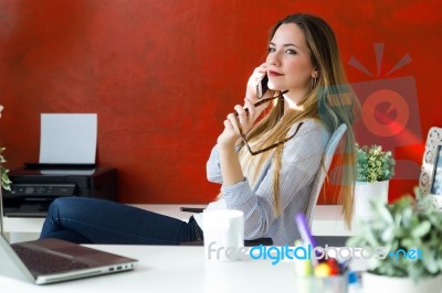 Beautiful Young Woman Using Her Mobile Phone In The Office Stock Photo