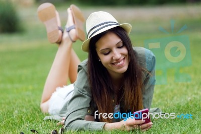 Beautiful Young Woman Using Her Mobile Phone In The Park Stock Photo