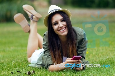 Beautiful Young Woman Using Her Mobile Phone In The Park Stock Photo