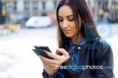 Beautiful Young Woman Using Her Mobile Phone In The Street Stock Photo