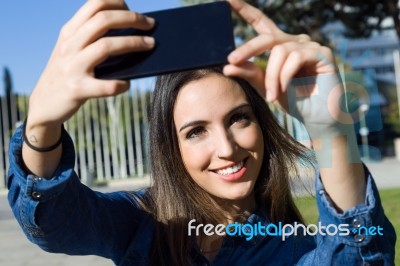 Beautiful Young Woman Using Her Mobile Phone In The Street Stock Photo