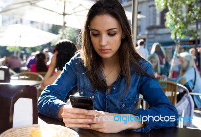 Beautiful Young Woman Using Her Mobile Phone In The Street Stock Photo