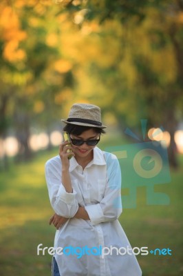 Beautiful Young Woman Wearing Sun Glassea Nd Straw Hat Talking O… Stock Photo