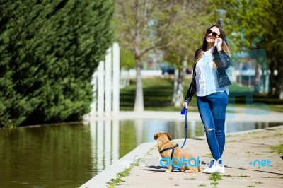 Beautiful Young Woman With Her Dog Using Mobile Phone Stock Photo