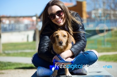 Beautiful Young Woman With Her Dog Walking In The Park Stock Photo