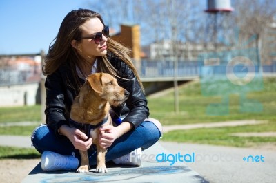 Beautiful Young Woman With Her Dog Walking In The Park Stock Photo