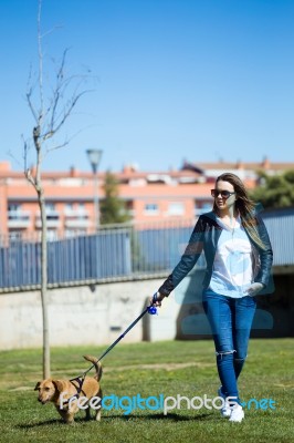 Beautiful Young Woman With Her Dog Walking In The Park Stock Photo